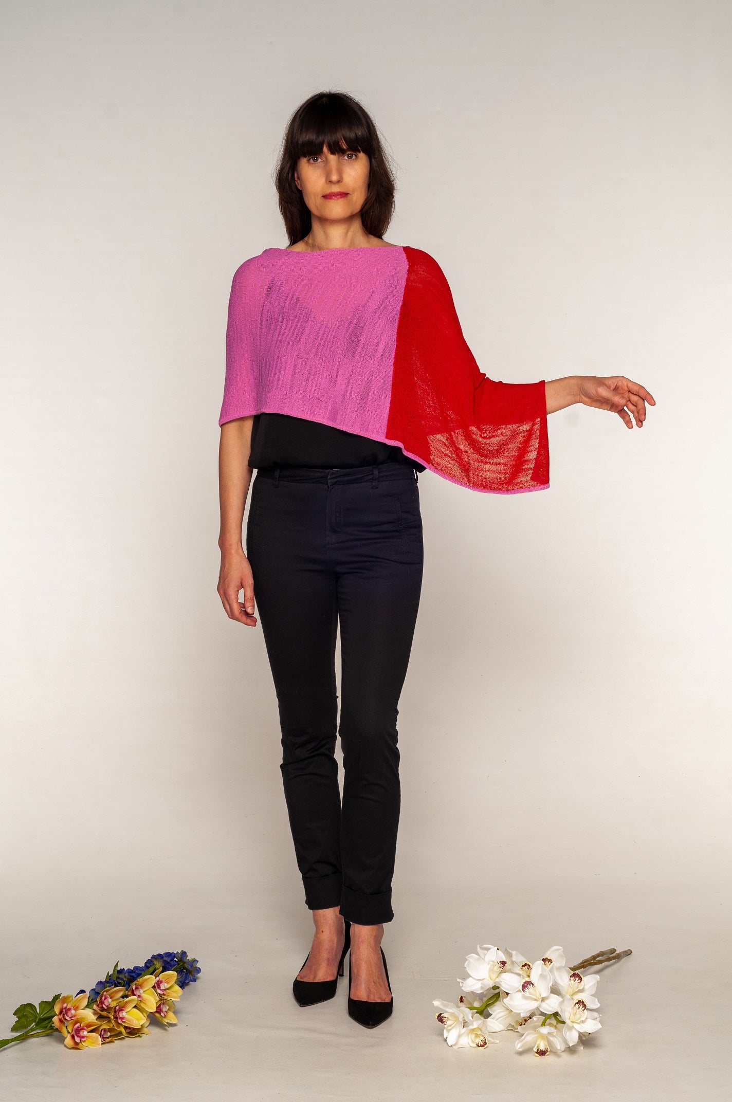 poncho rosso e rosa indossato in modo asimmetrico