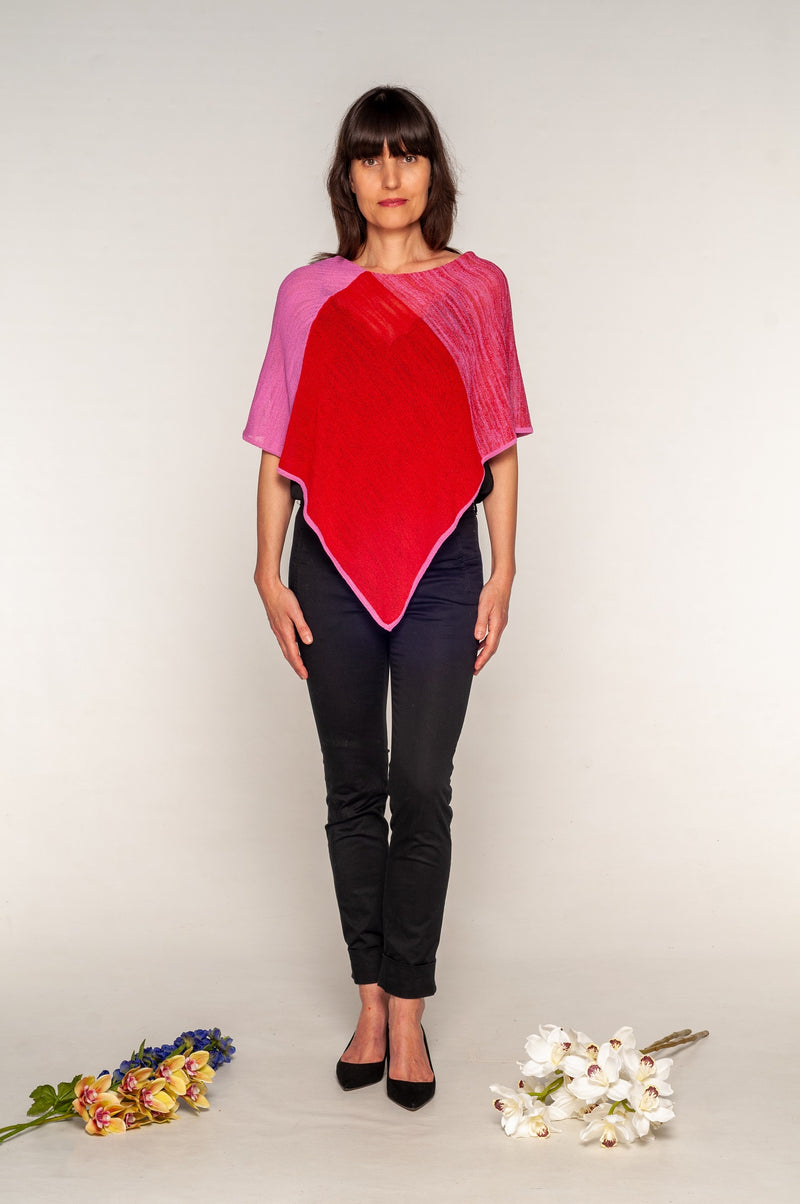 Red poncho with pink trim worn with long forward tip